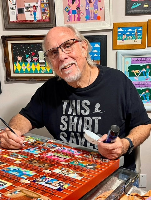 Bill Brill, a naive/folk artist from Tulsa, Oklahoma, working on a vibrant acrylic painting in his studio, surrounded by his whimsical and colorful artwork.