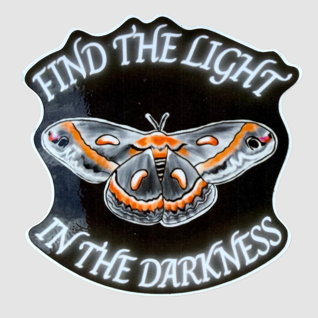 Inspirational 2.5-inch die-cut moth sticker featuring a gray and orange Cecropia moth on a black background with the words Find the Light in the Darkness.